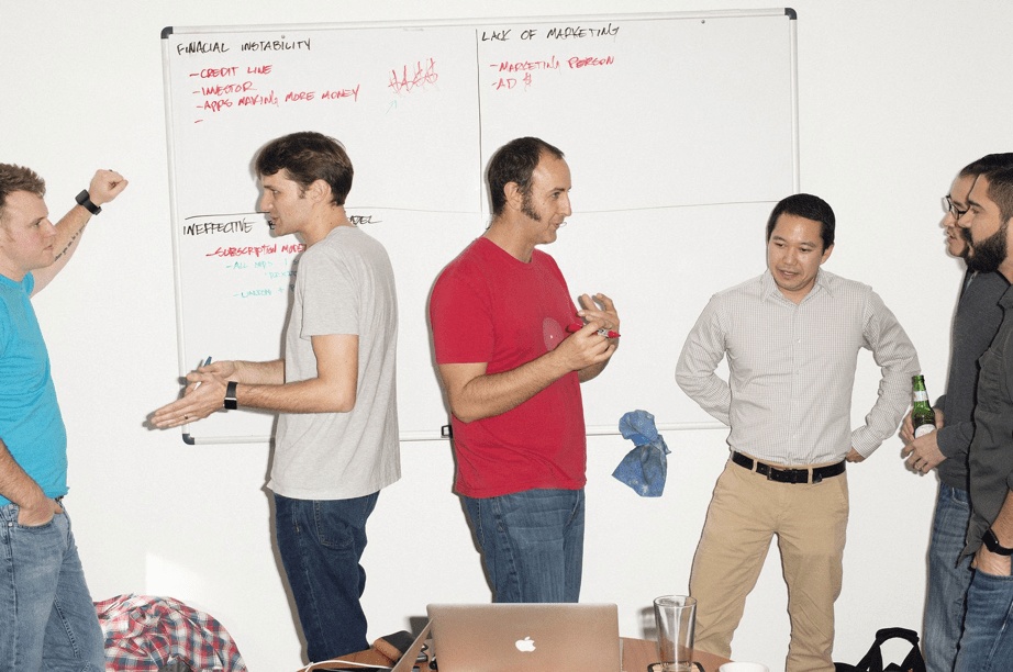 Pixite team discussing business challenges in front of a whiteboard