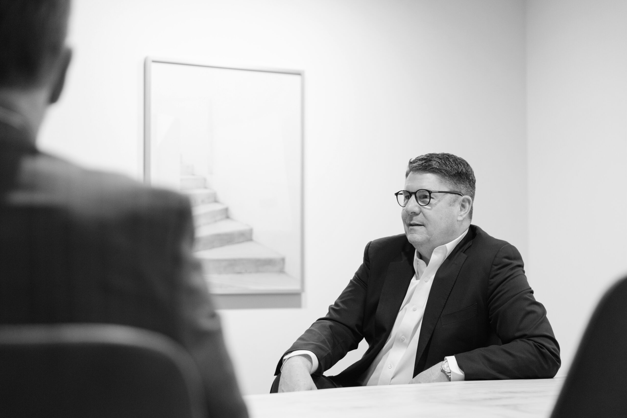 Brad Benbow seated at a meeting table with colleagues