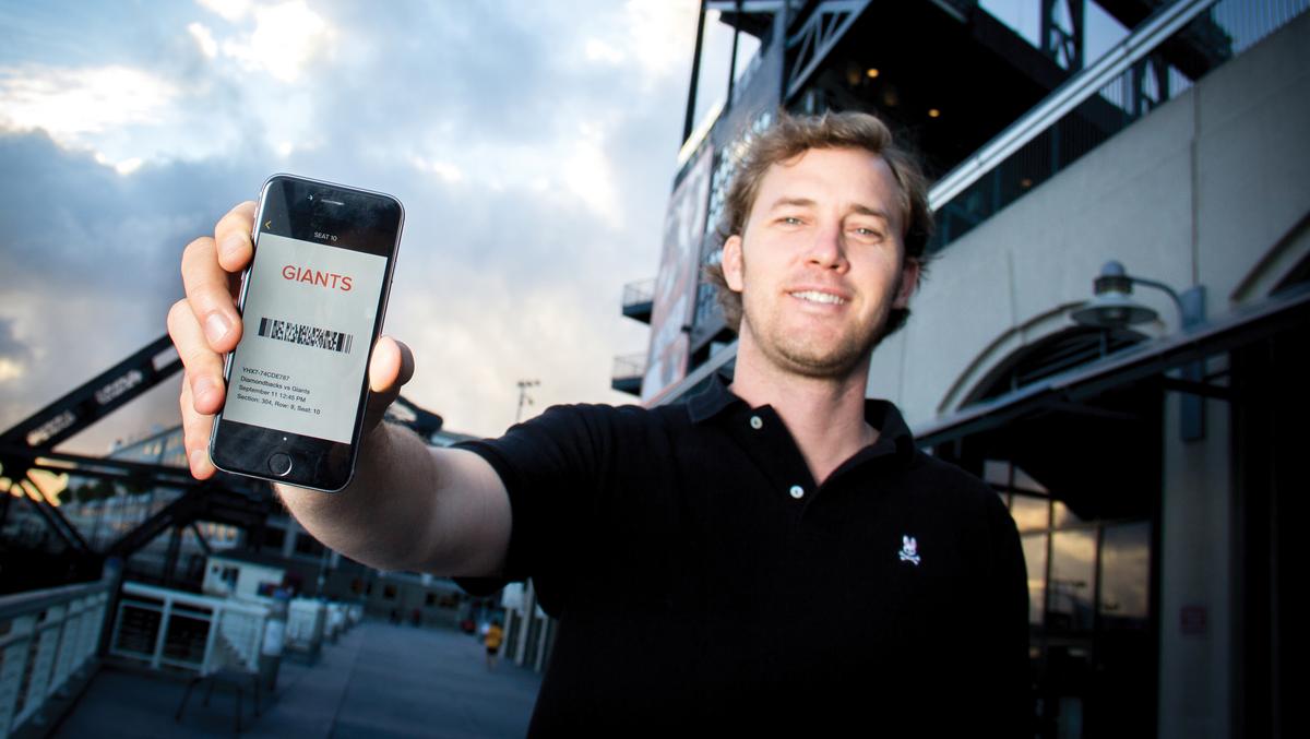 Brad Griffith holding a phone displaying a Giants mobile ticket outside the San Francisco ballpark