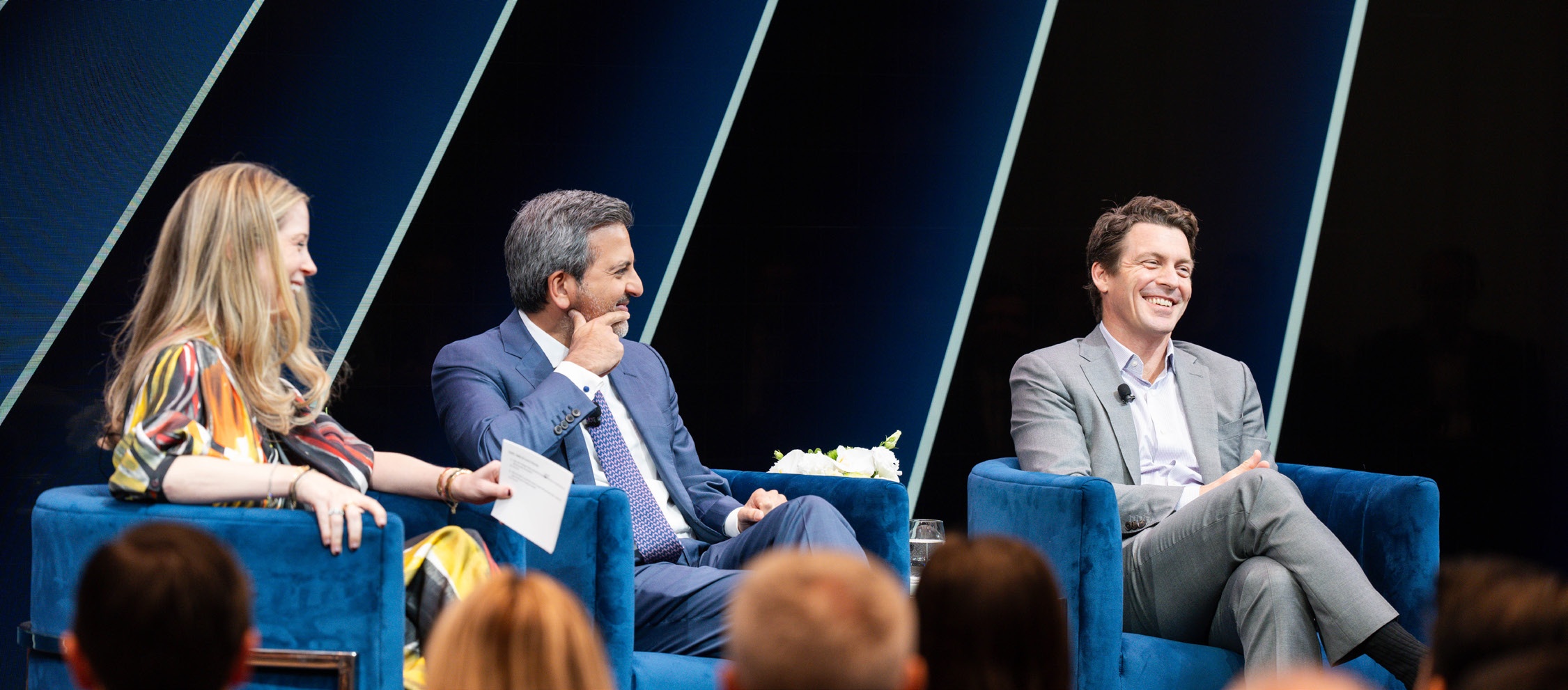 Emily Yoder, Mohit Assomull and Brad Marshall seated onstage at a Blackstone Secured Lending investor event