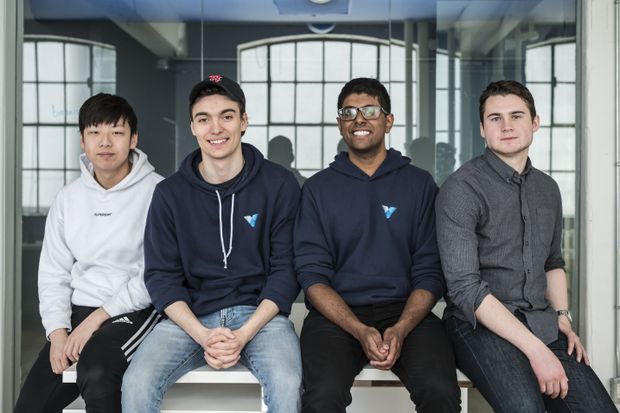 Four members of the early Voiceflow team seated together in an office, with Braden Ream second from left