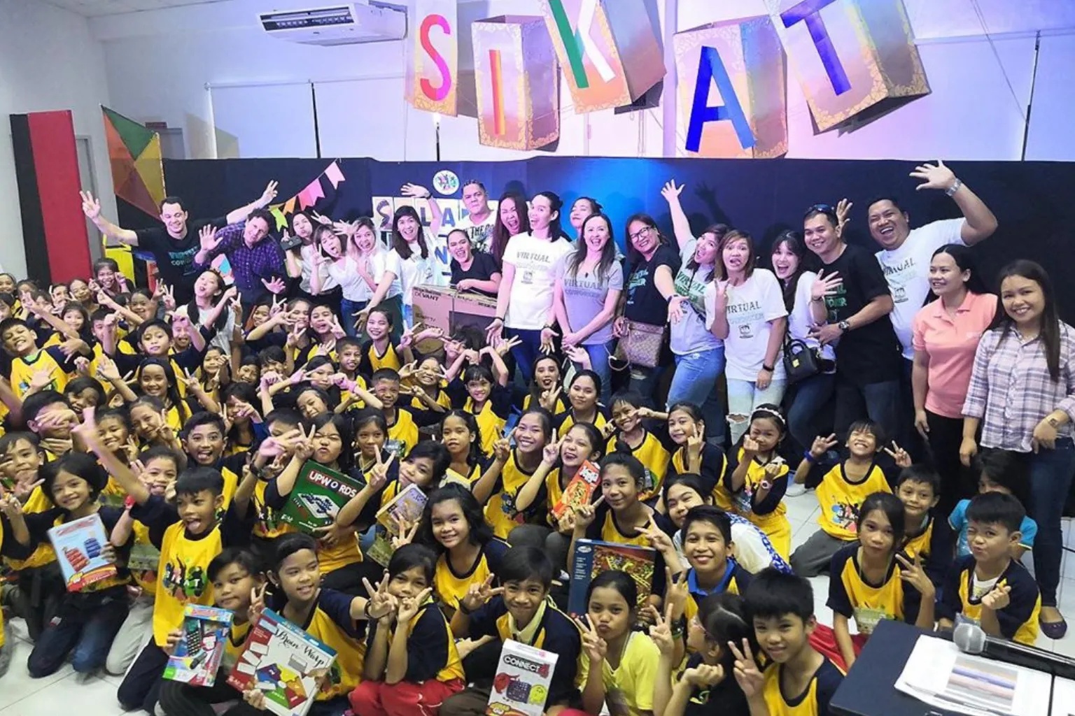 Virtual Coworker team members and children pose together at a community gathering