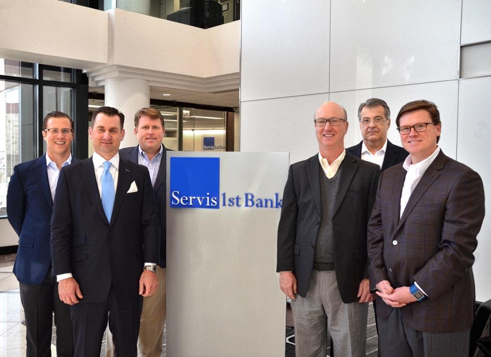 Six members of the ServisFirst Nashville board standing beside a bank sign, with Bradford Vieira second from left.