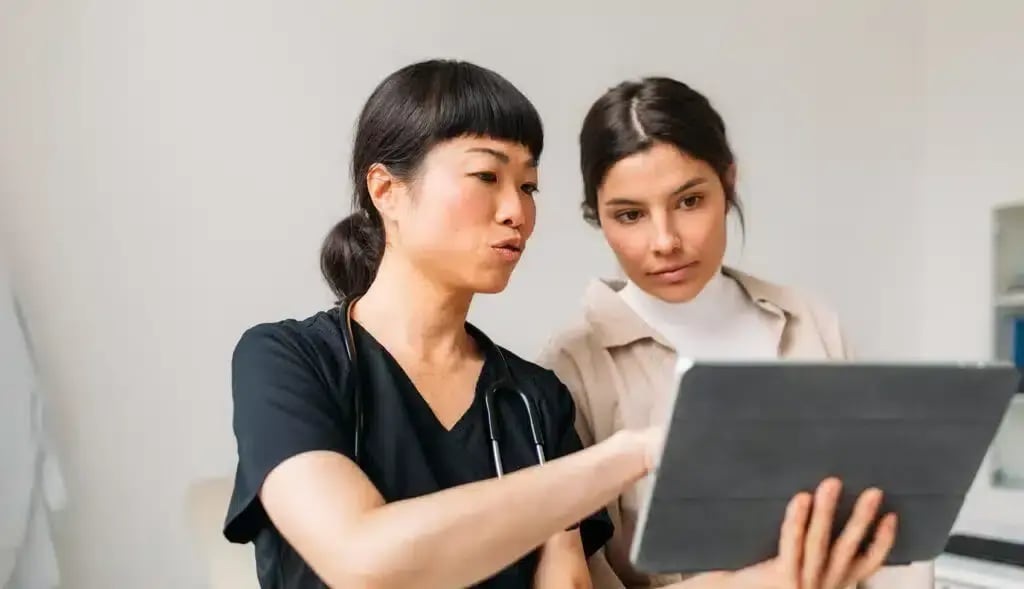 A clinician and an adult looking at a tablet, in BrainCheck’s illustrative website photograph