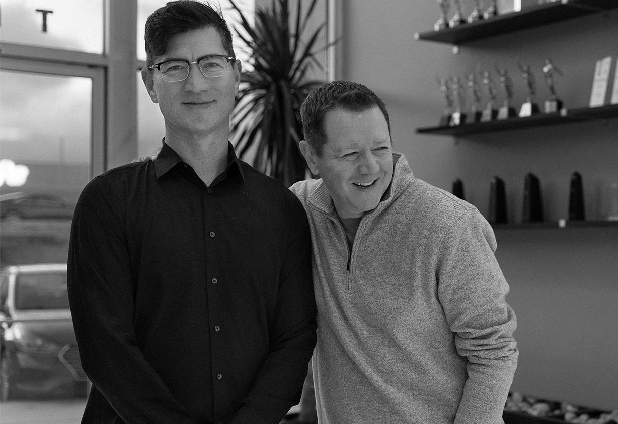 Braintrust co-founders Kurt Ouchida and Michael Coldwell standing together in the agency office