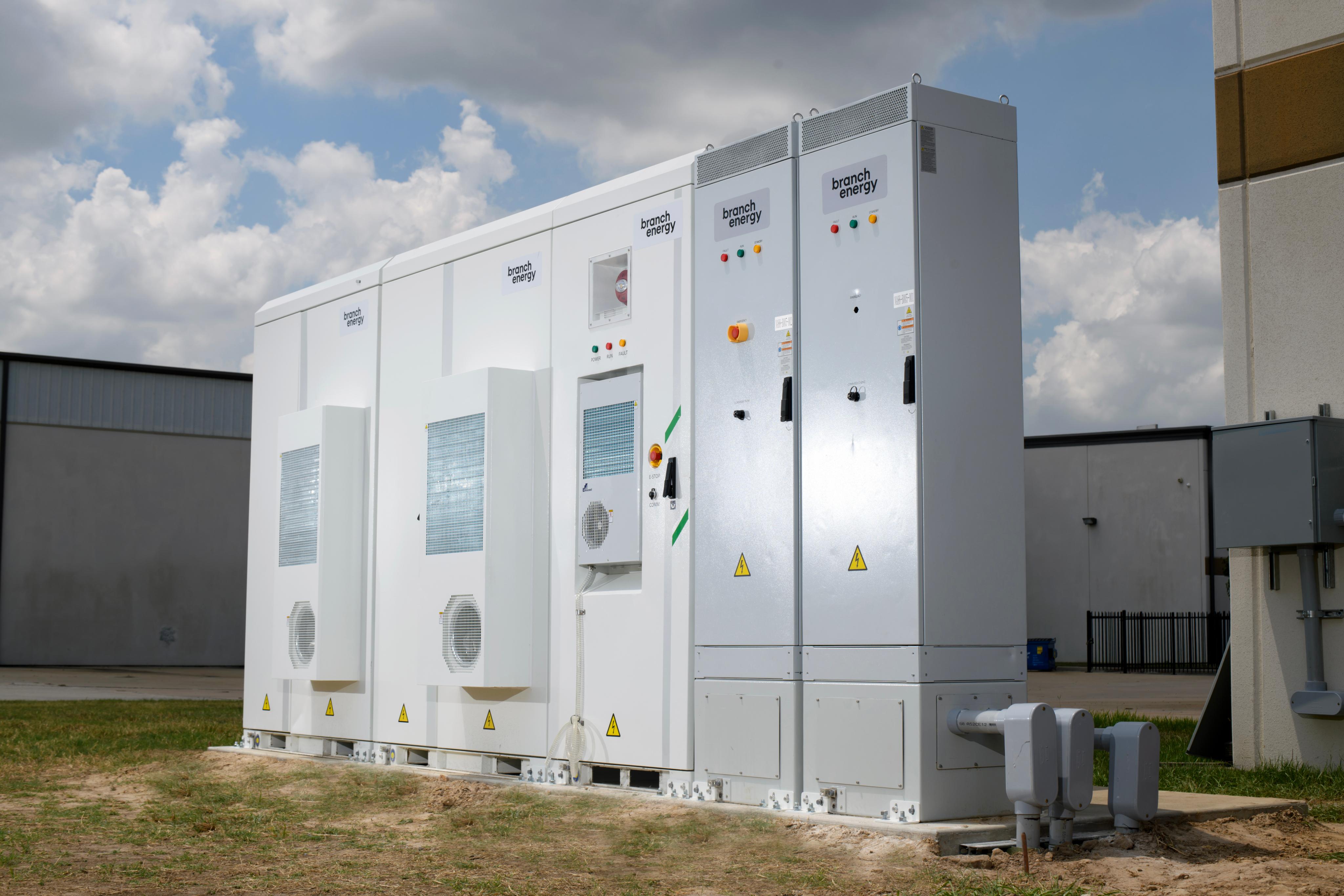 A row of Branch Energy commercial battery cabinets beside a building