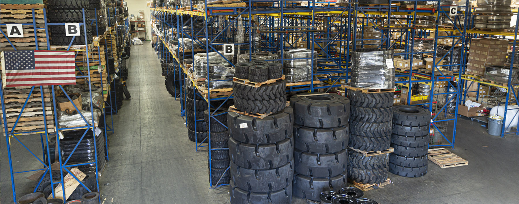 Warehouse racks filled with tires, pallets and boxed stock