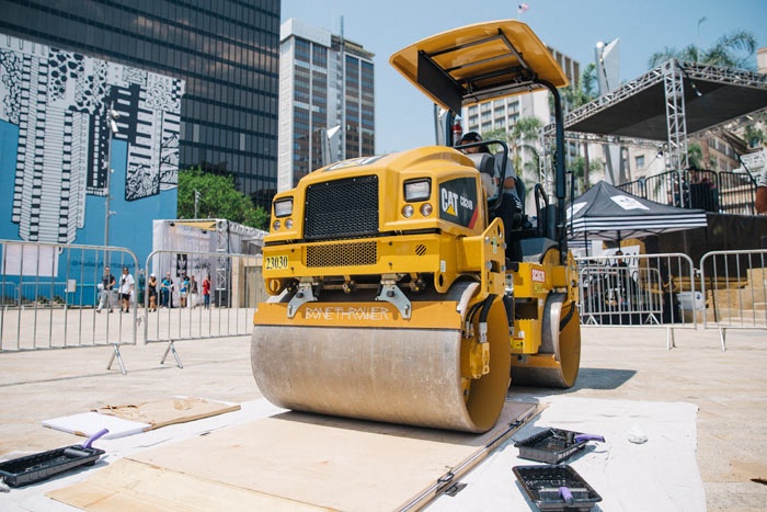 A yellow steamroller presses a large linocut print at Destination San Diego