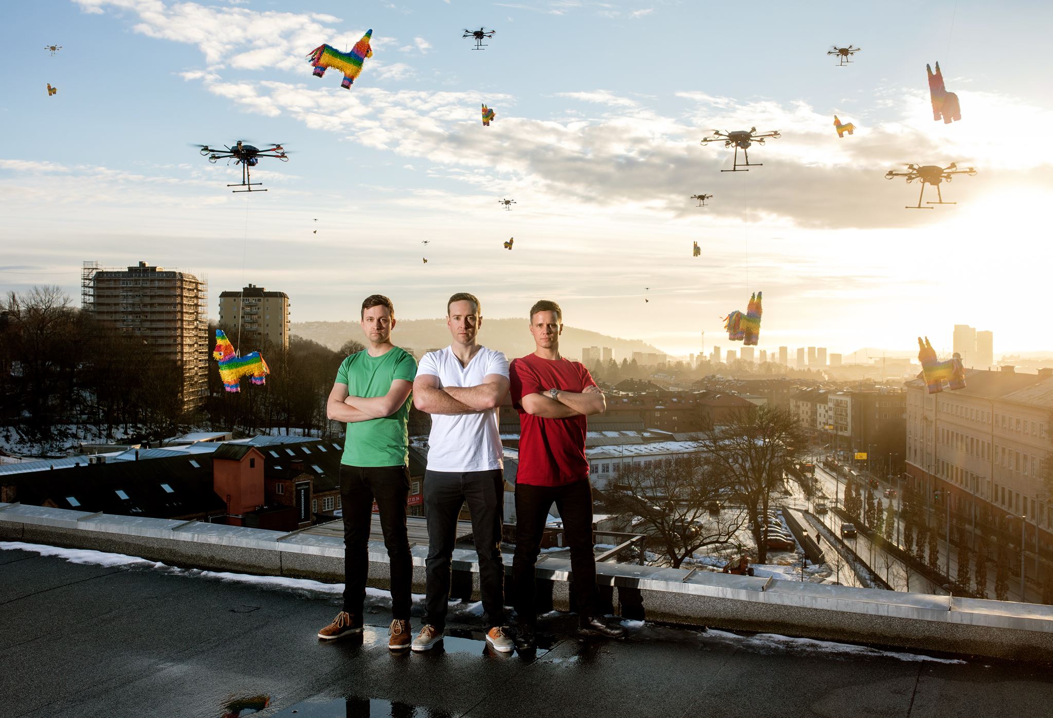 Brandon Brock, center, with the Flying Piñata team on an Oslo rooftop as drones carry colorful piñatas overhead