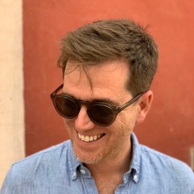 Brandon McGraw smiling outdoors in sunglasses and a blue shirt