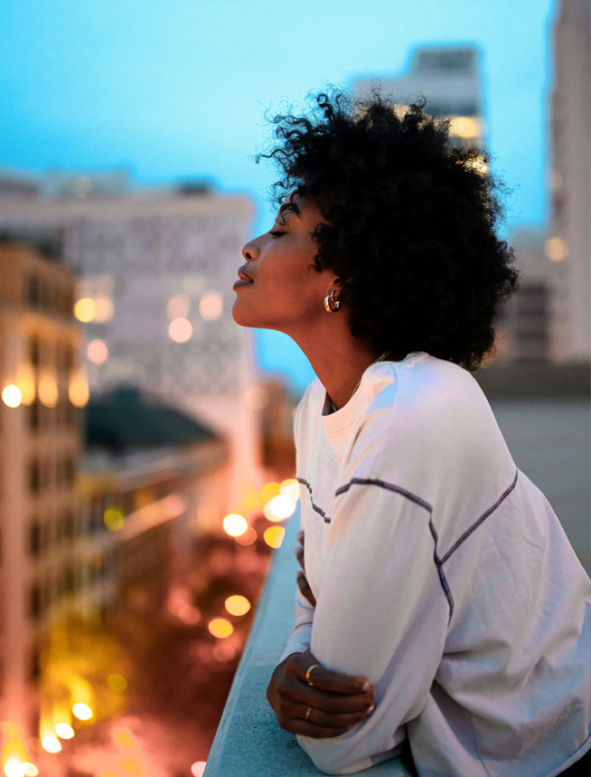 A traveler looking over a city at dusk