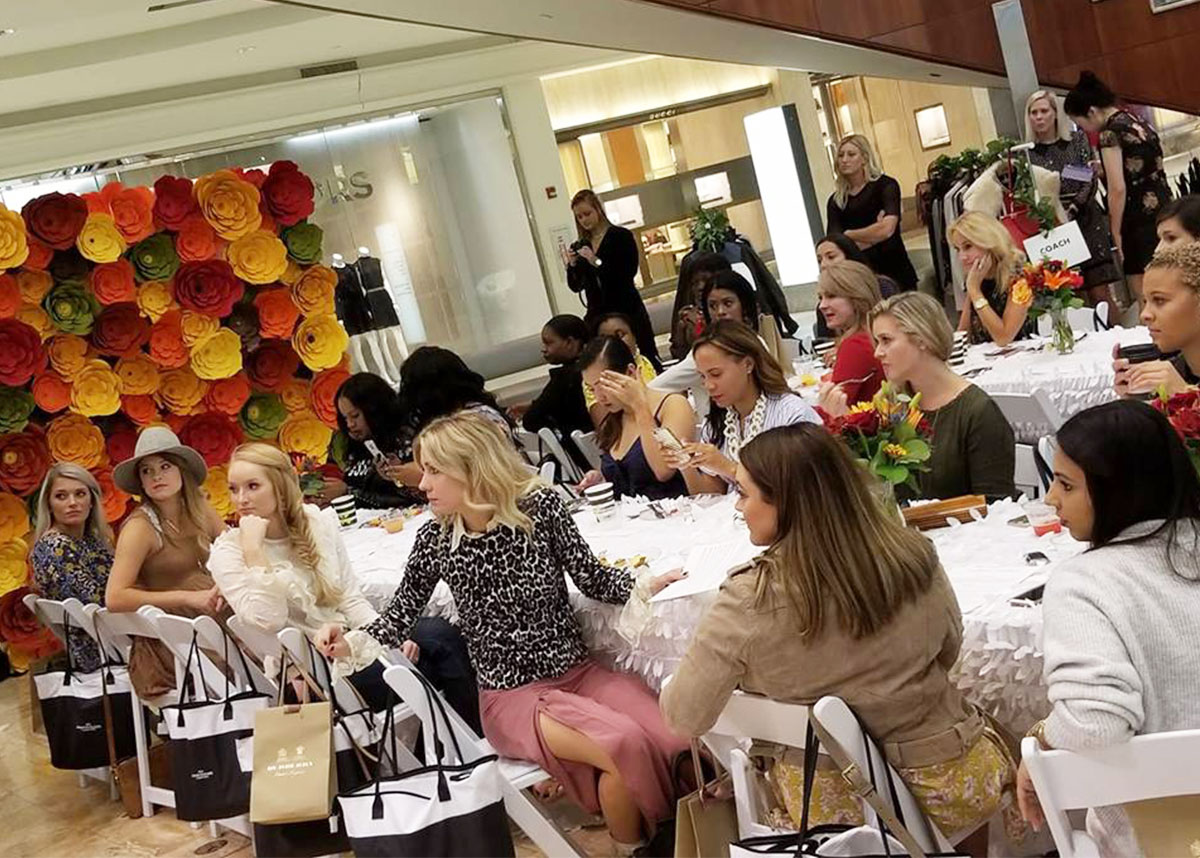 Guests seated around a long table at a colorful influencer event