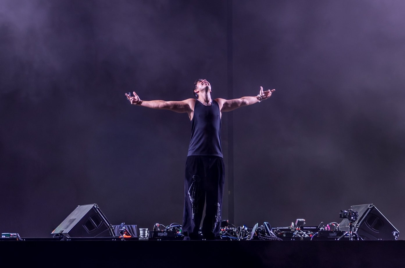A performer behind the decks with arms outstretched on Breakaway’s Atlanta stage