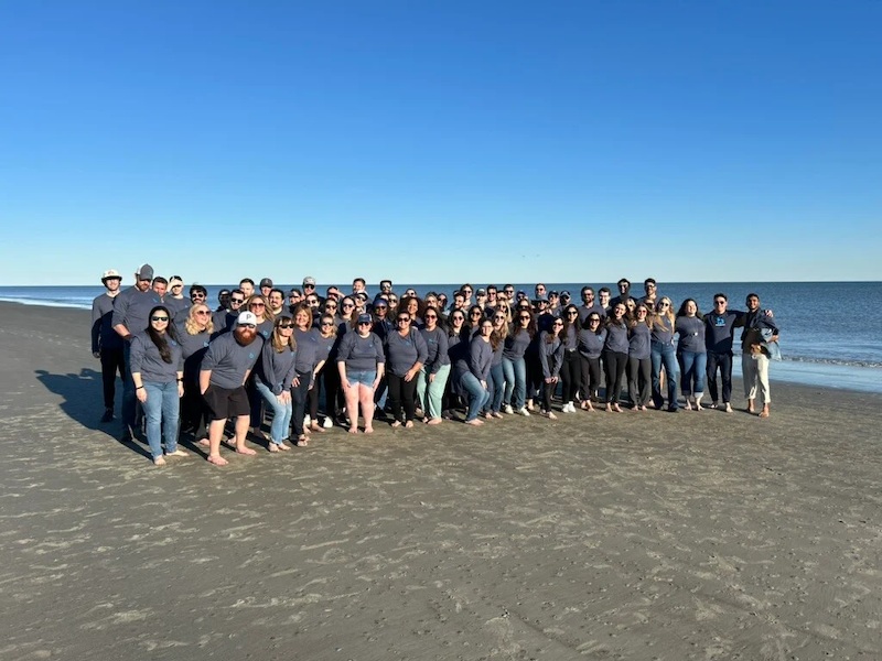 Breezeway team gathered together on a beach