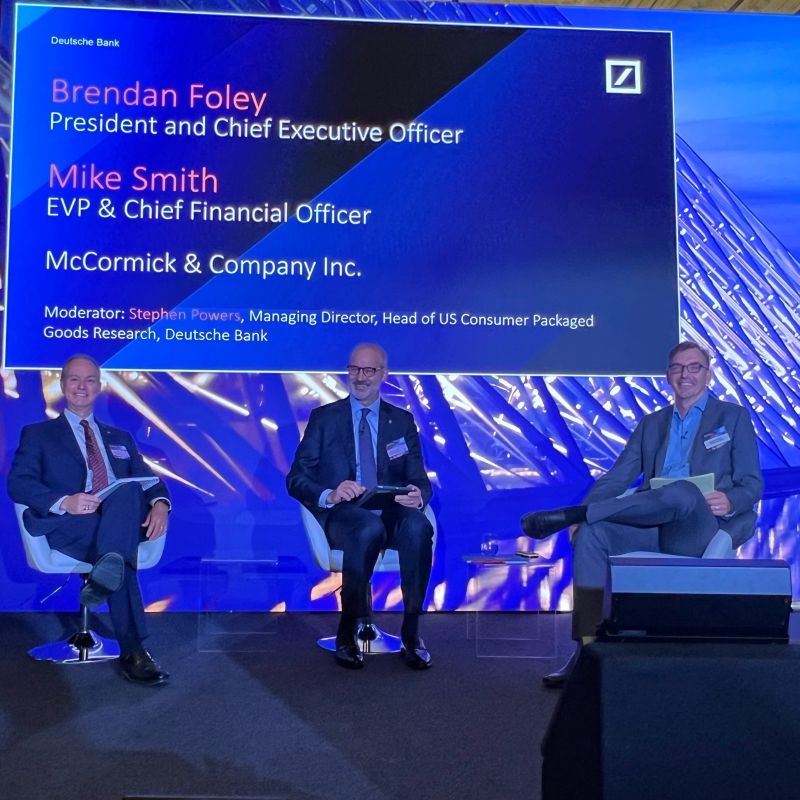 Brendan Foley, Mike Smith and moderator Steve Powers seated on stage at the Deutsche Bank Global Consumer Conference in Paris