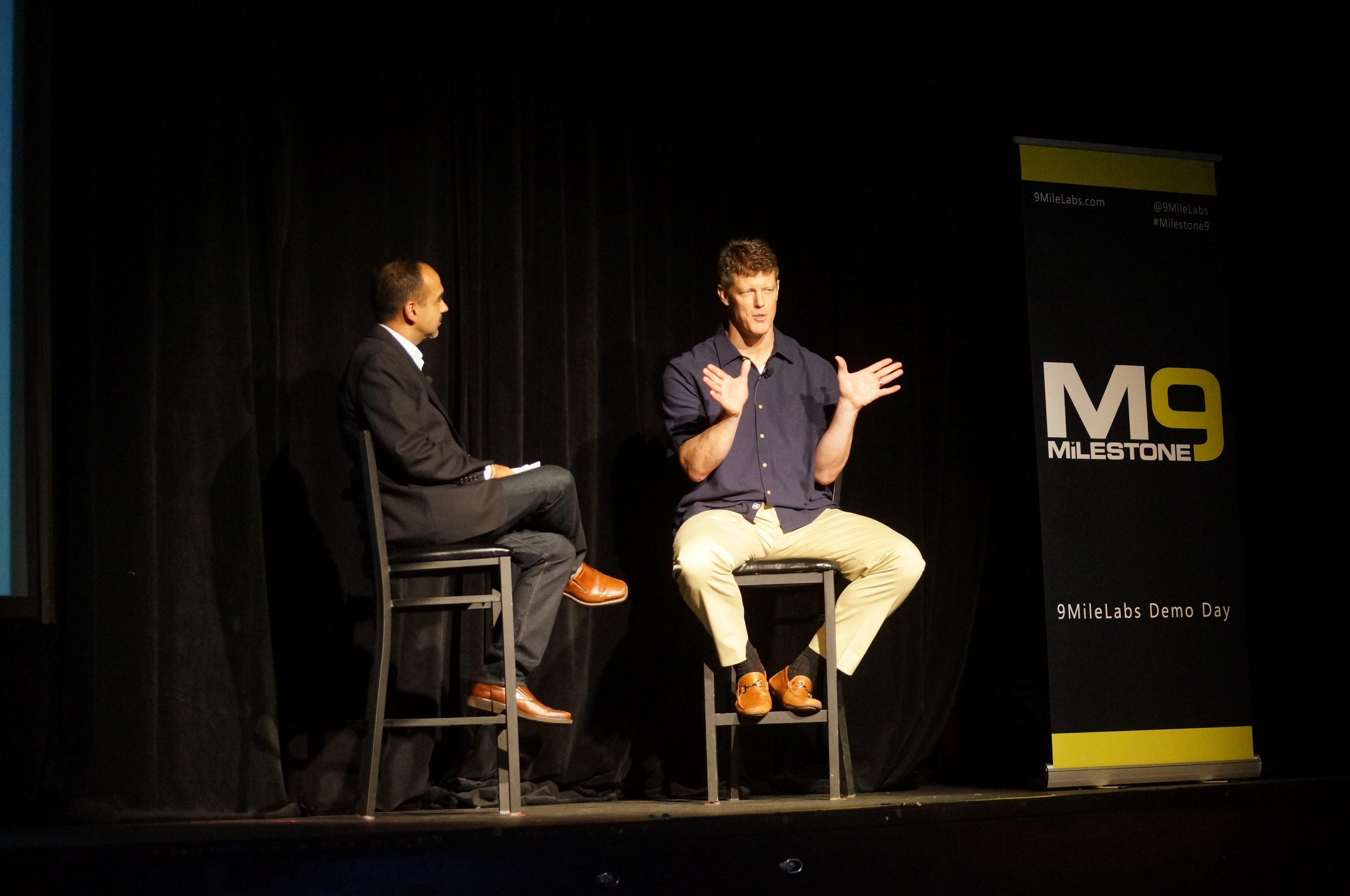 Sanjay Puri interviewing Brent Frei onstage at the 2015 Milestone 9 event