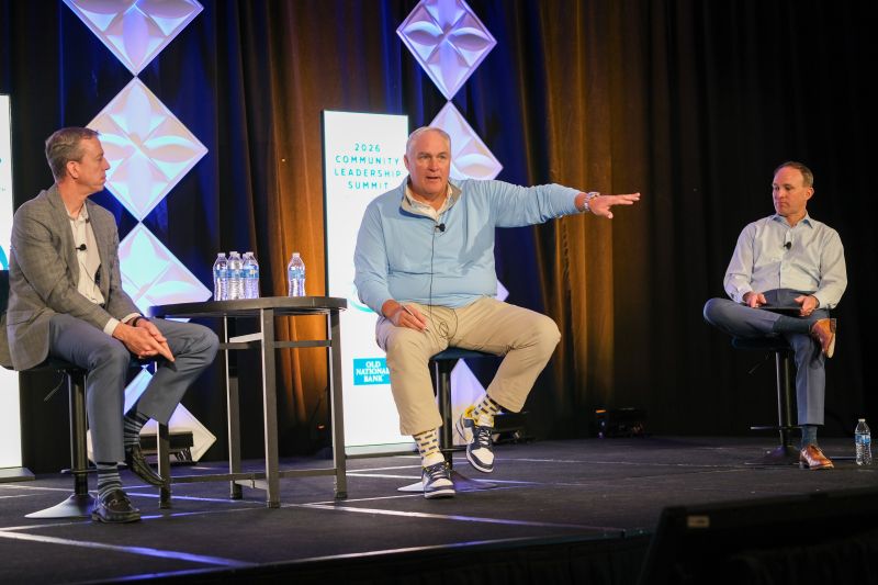 Three participants seated onstage during a discussion at Old National’s Community Leadership Summit