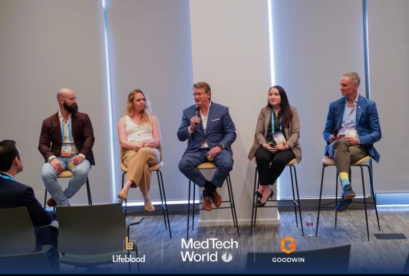 Bret Boudousquie, seated in the center, speaking into a microphone during a Houston founder panel