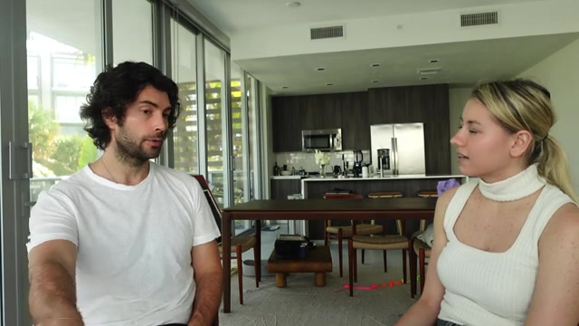 Brett Allcorn speaking with an interviewer in a bright room