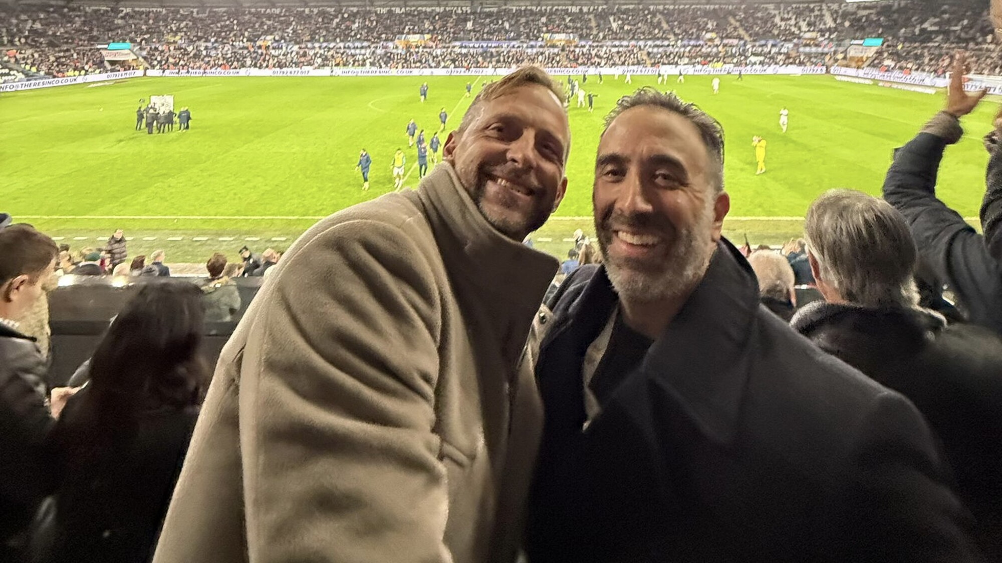 Brett Cravatt and Jason Cohen smiling in the stands at Swansea City’s stadium