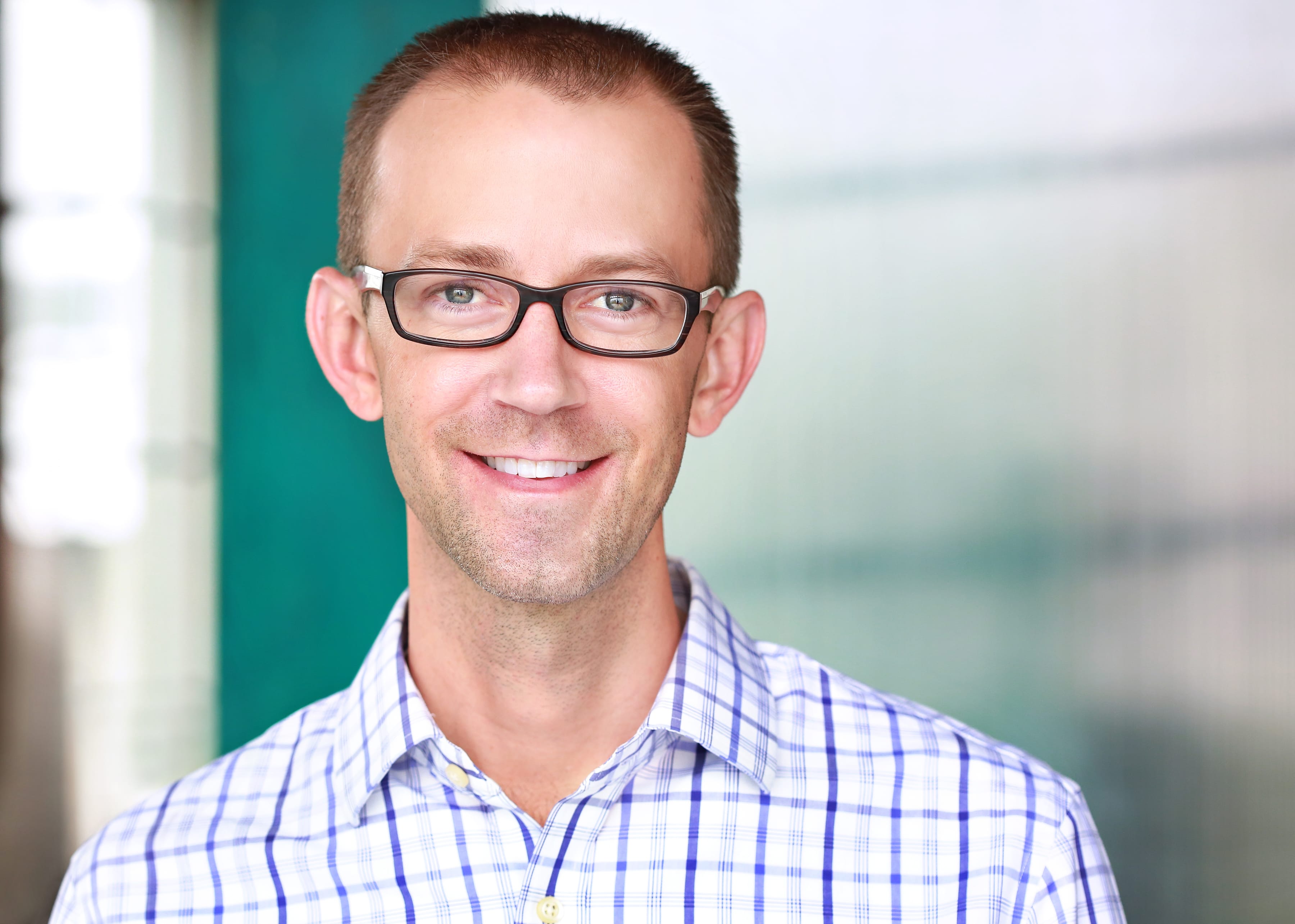 Brett Kohn during his Thinknear years, wearing glasses and a checked shirt