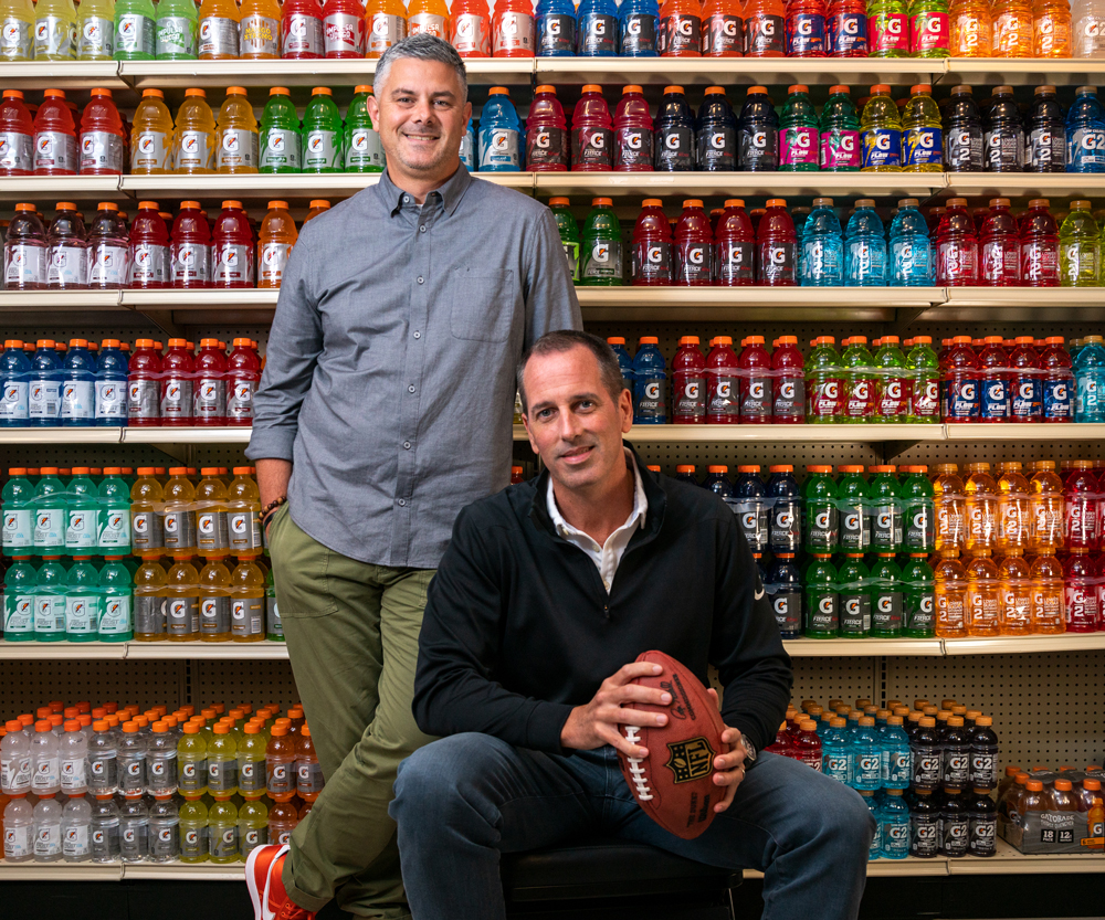 Brett O'Brien and Jeff Kearney posed in front of shelves filled with Gatorade bottles