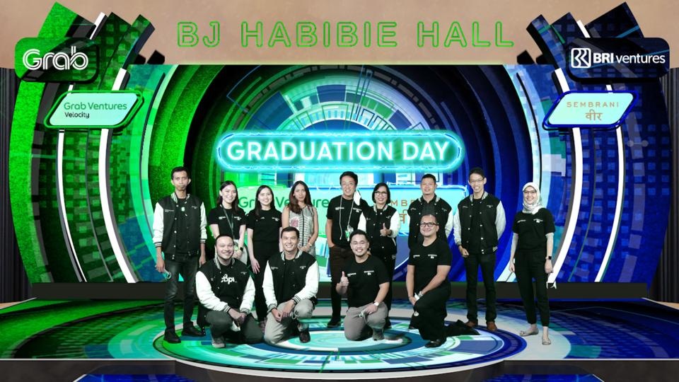 Participants at the Grab Ventures Velocity and Sembrani Wira graduation, with a green Graduation Day backdrop