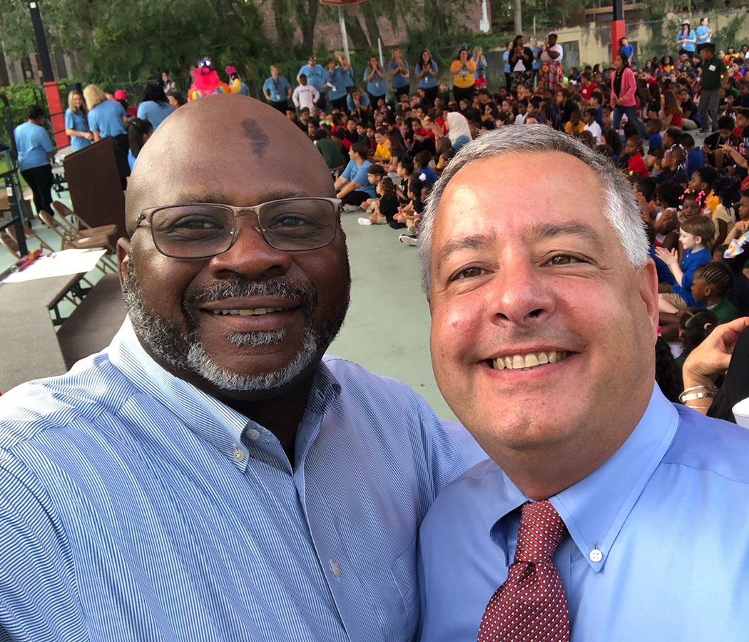 Brian Butler and school principal Woodland Johnson smiling during a school gathering