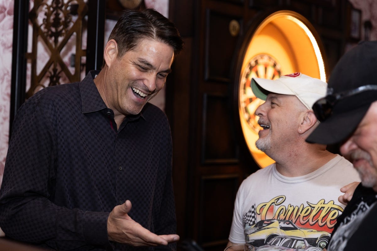 Brian Goudie, left, laughing during a conversation with two other people