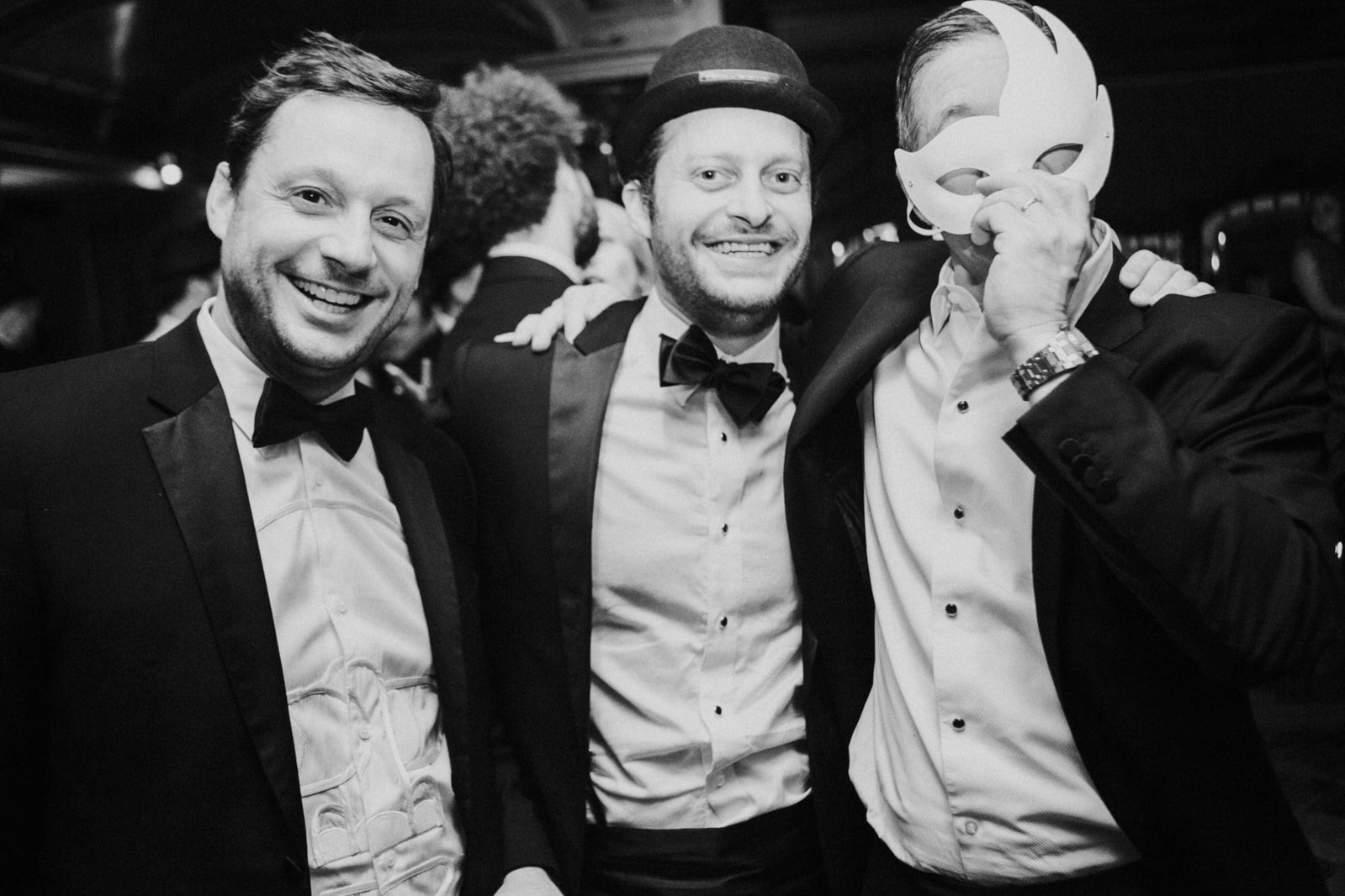 Aaron Ashmore, Michael Wein and Brian Kwait at a formal celebration, with Kwait holding a decorative mask