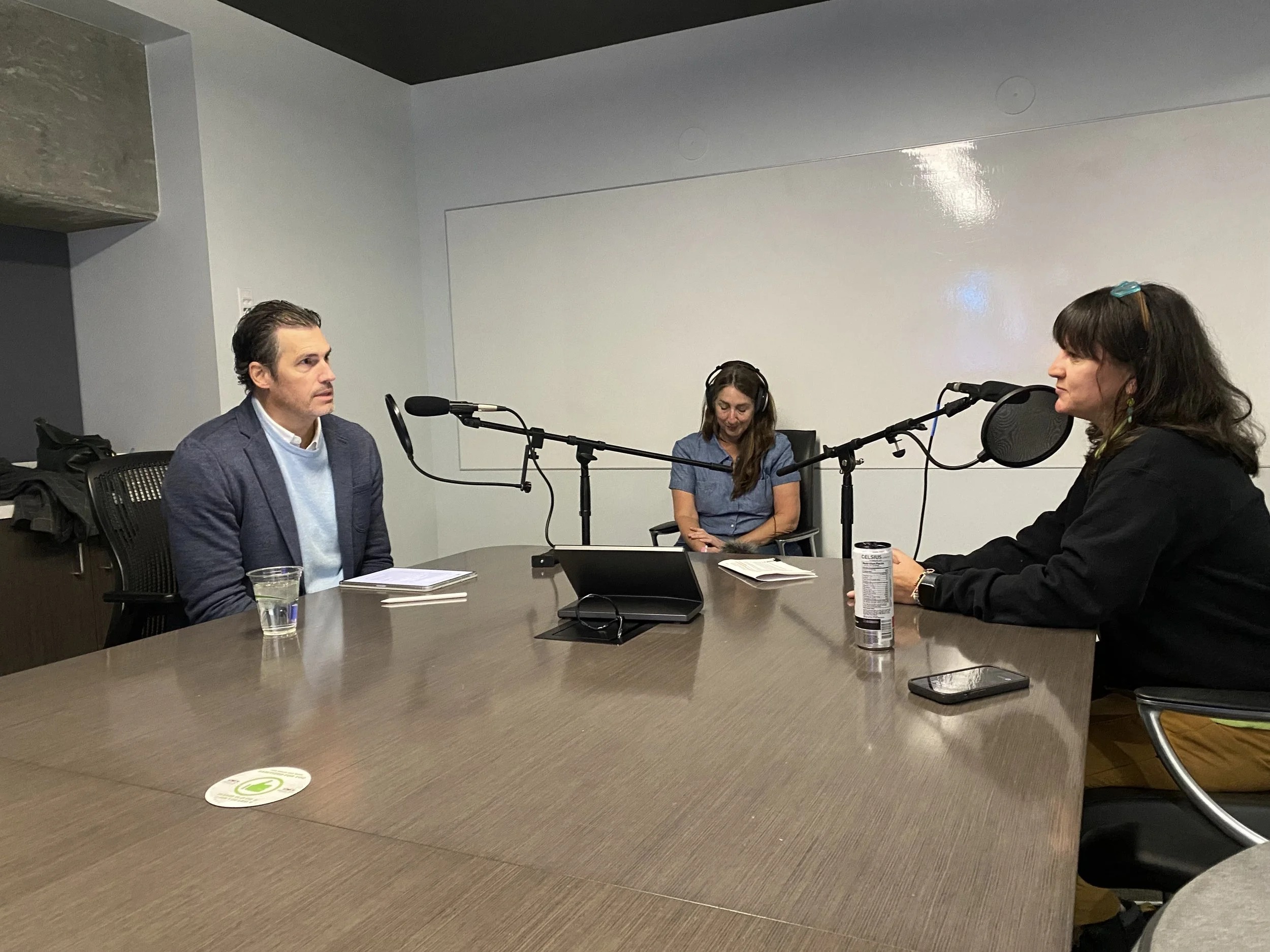 Brian Maughan seated at a conference table recording a Built podcast interview with Dawn Brown at Mercedes-Benz Stadium