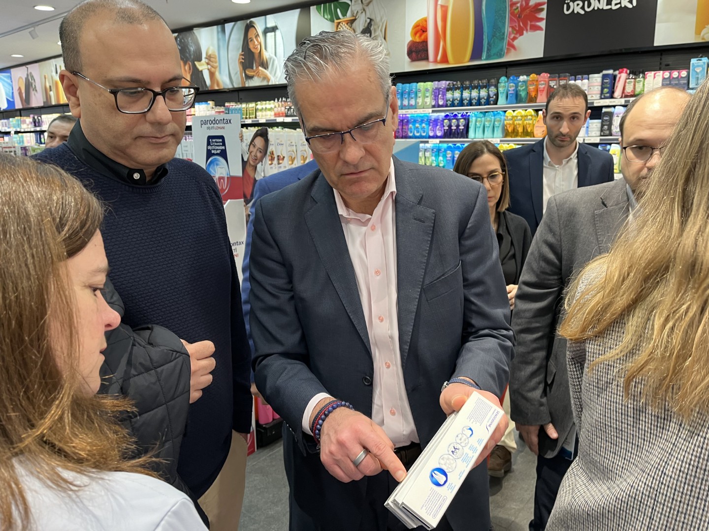 Brian McNamara examining a product box with colleagues during a store visit in Istanbul