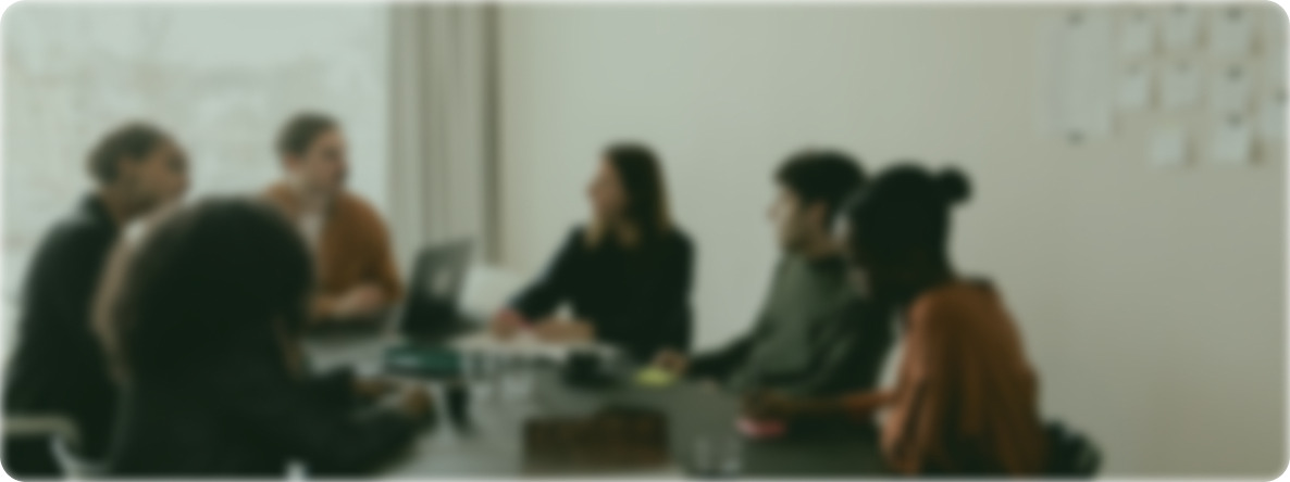 A softly focused Camber team meeting around a table