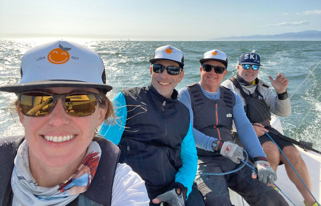 The Orange You Glad sailing crew standing together beside the water