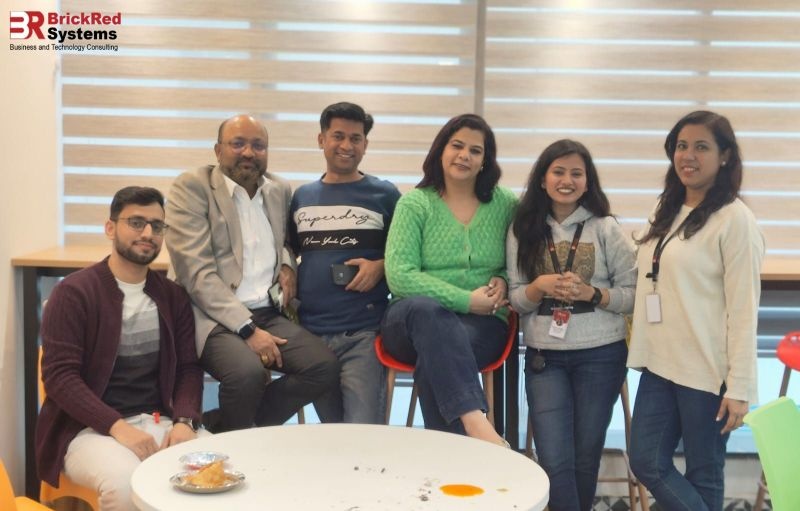 BrickRed colleagues seated around a circular table in an office lounge