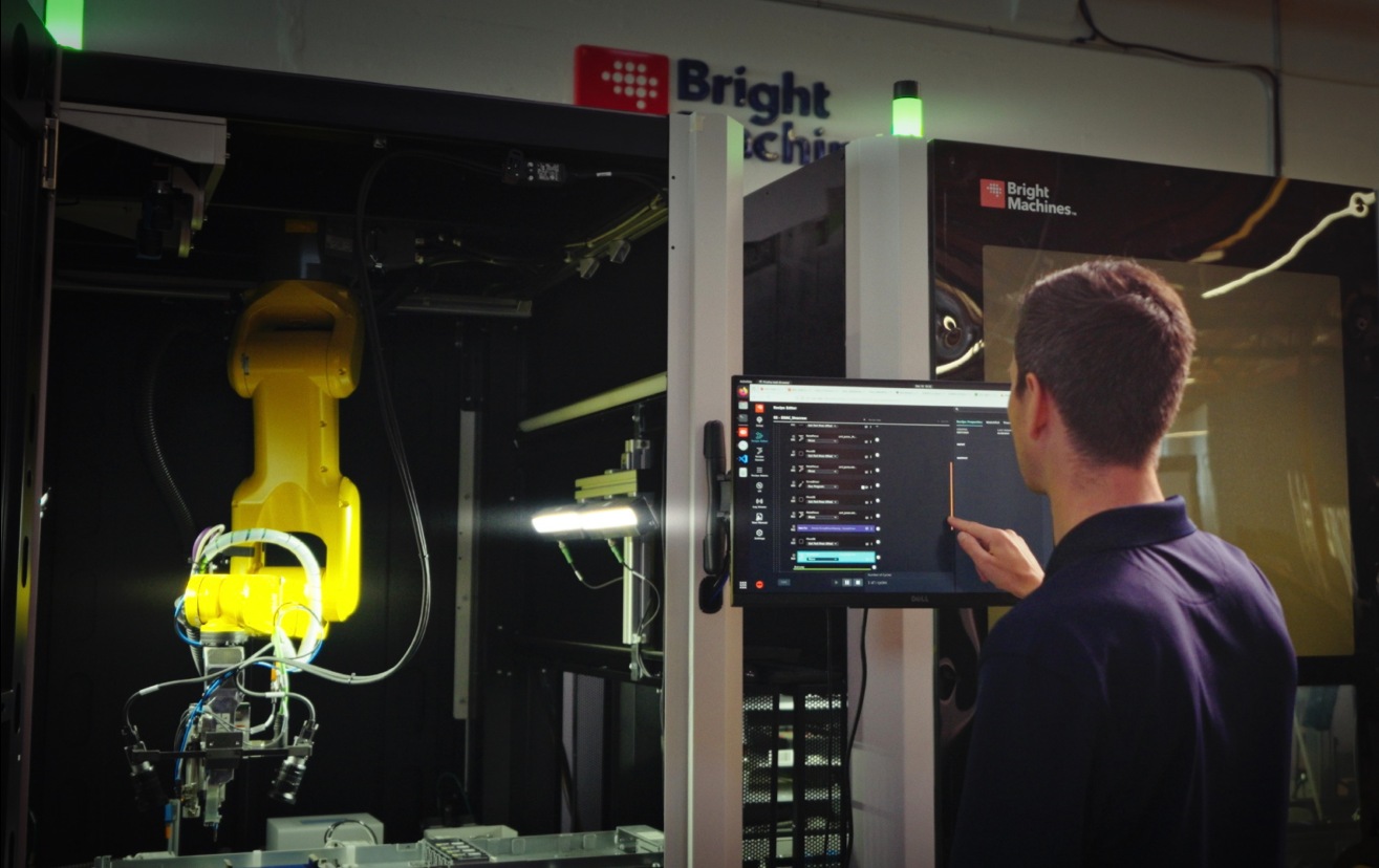 An operator uses Brightware software at an enclosed robotic assembly cell