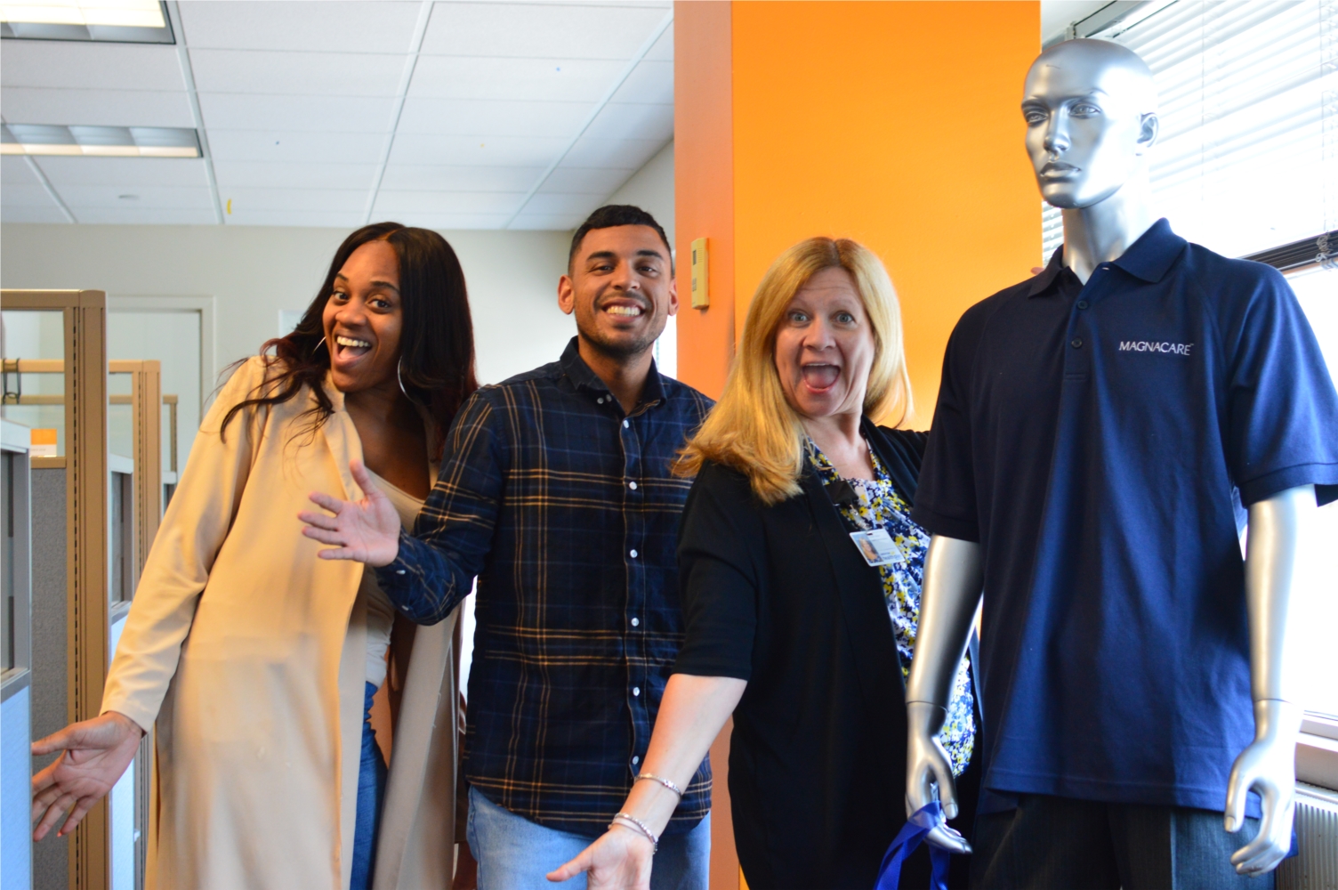 Brighton workplace colleagues pose beside a mannequin wearing a MagnaCare polo shirt