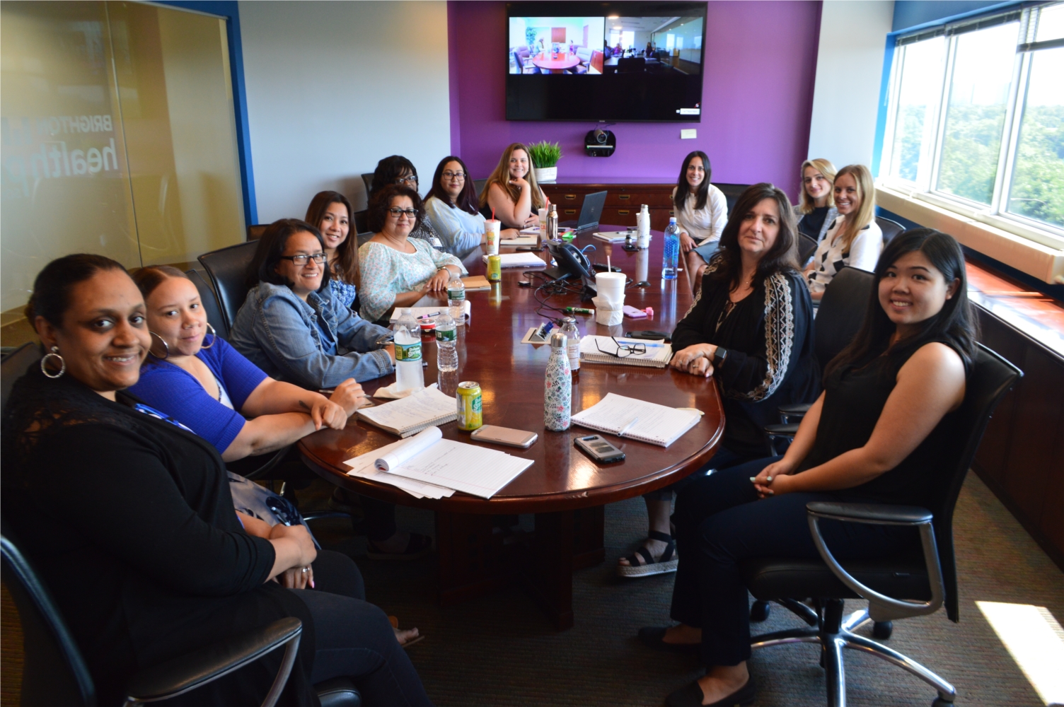Brighton colleagues seated around a conference table in a colorful meeting room