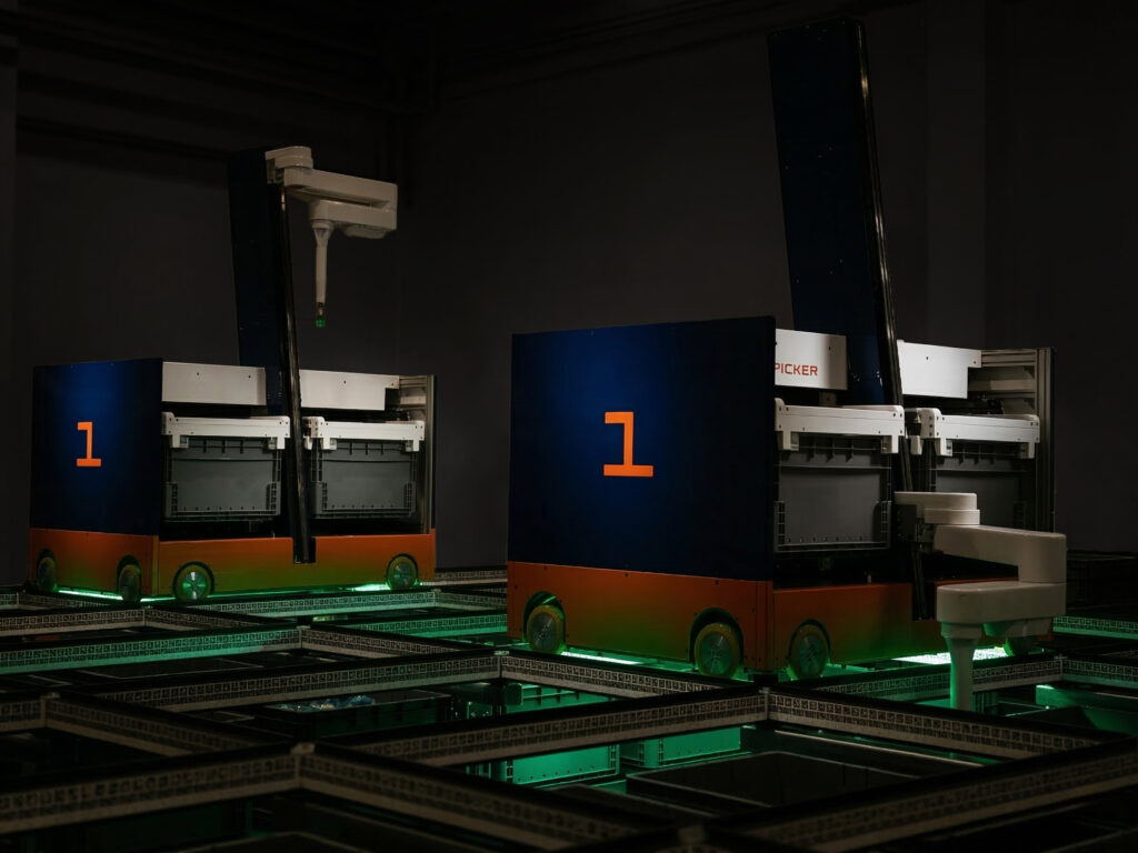 Product rendering of two Gridpicker robots operating above storage shelves