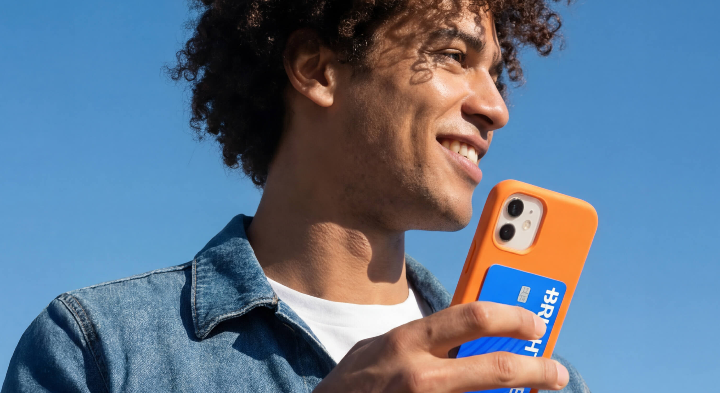 Brightwell promotional photograph showing a person holding an orange phone and a blue Brightwell payment card