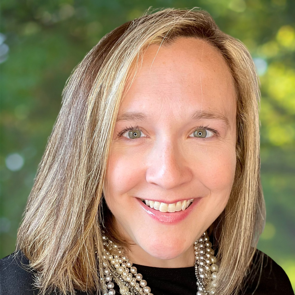 Brittany White in a professional portrait against a green background