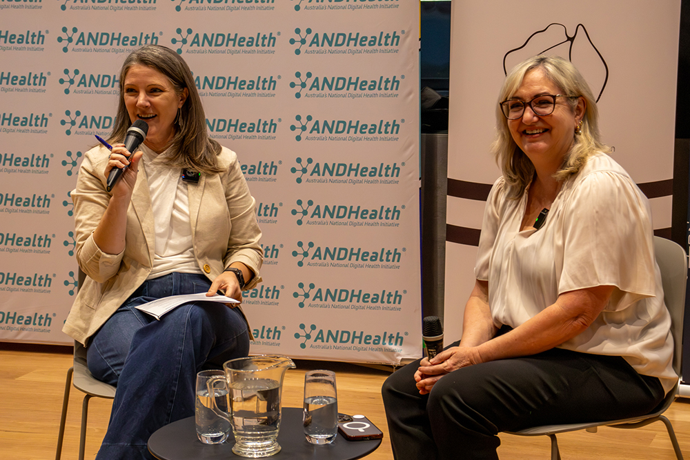 Bronwyn Le Grice, seated on the left, speaking into a microphone at an ANDHealth event