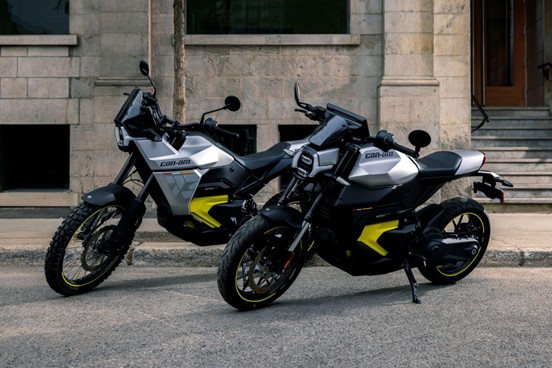 Can-Am Origin and Pulse electric motorcycles parked together on a street