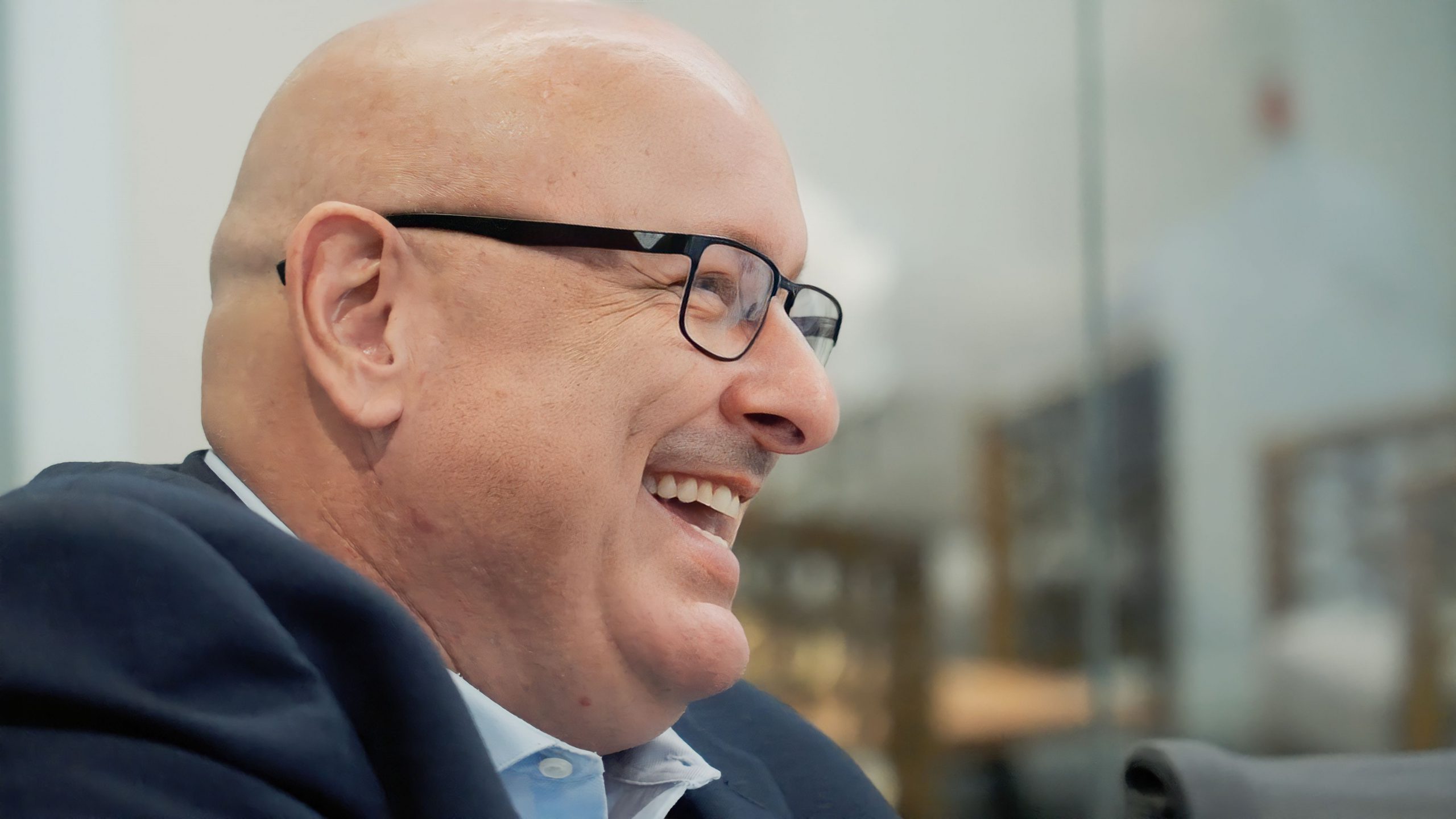 Bruce Springer smiling in conversation, photographed from the side