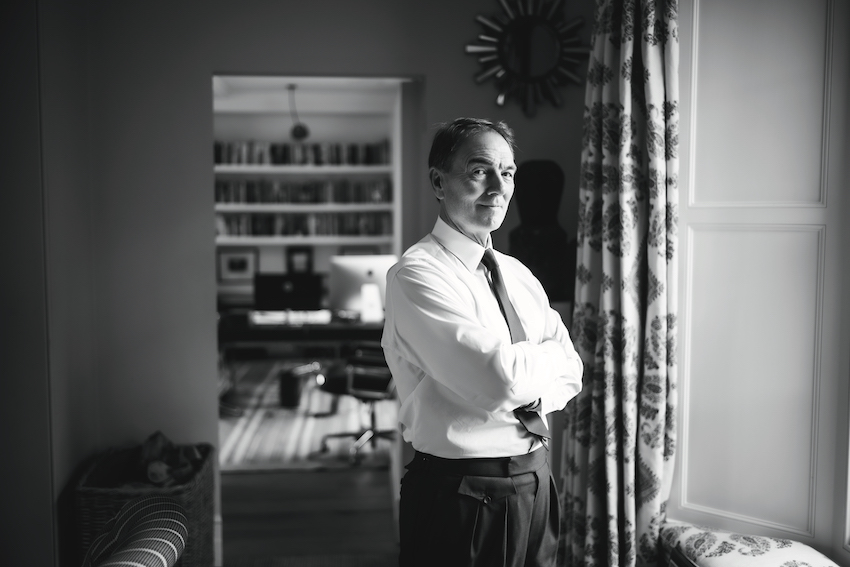 Brunswick Group founder Sir Alan Parker standing in a London room