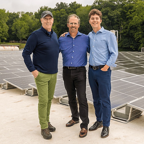 Al Subbloie with Gilman Brothers representatives on a rooftop overlooking solar panels