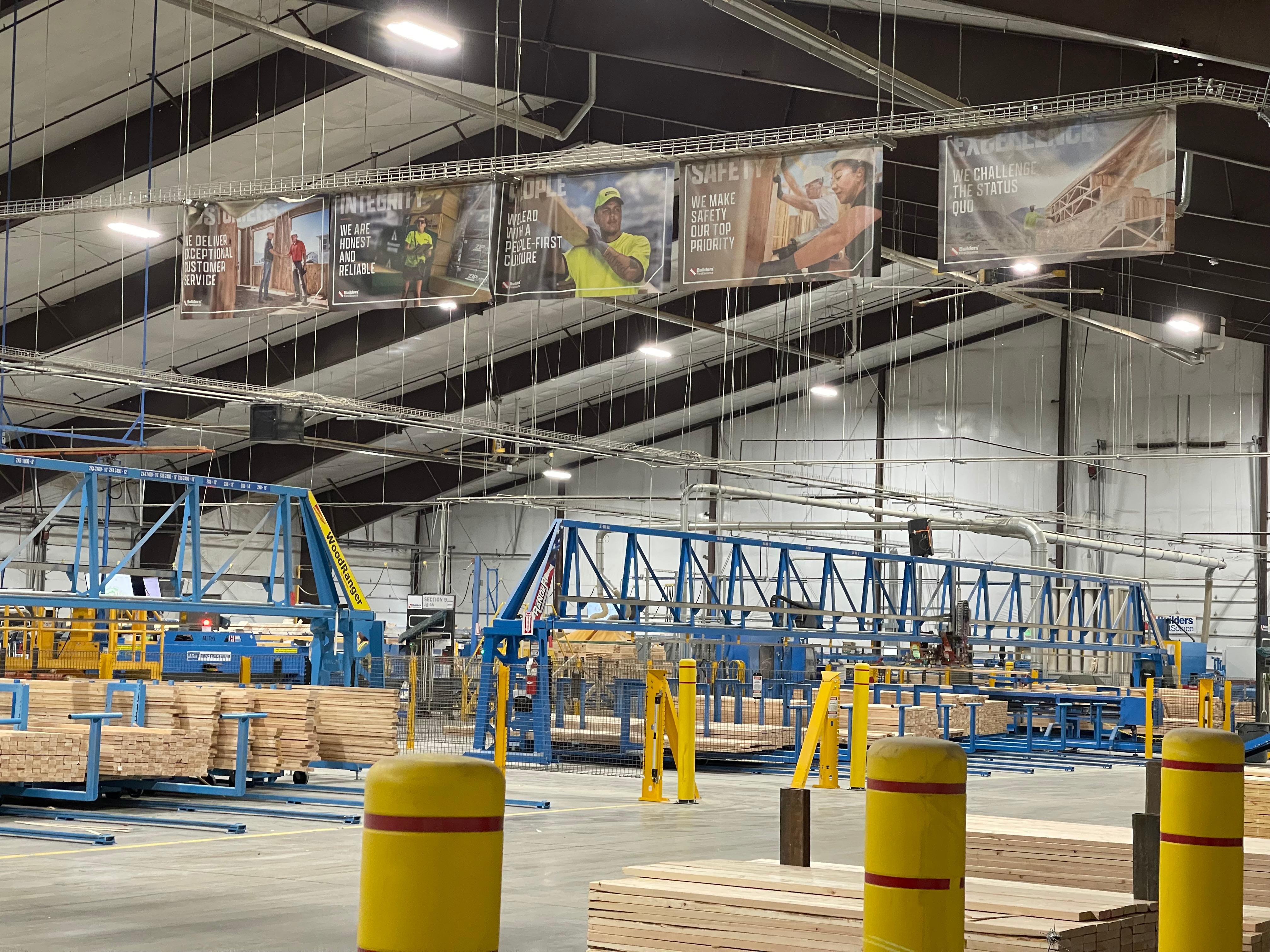 Truss assembly equipment and stacked lumber inside the Builders FirstSource facility in Lindon, Utah