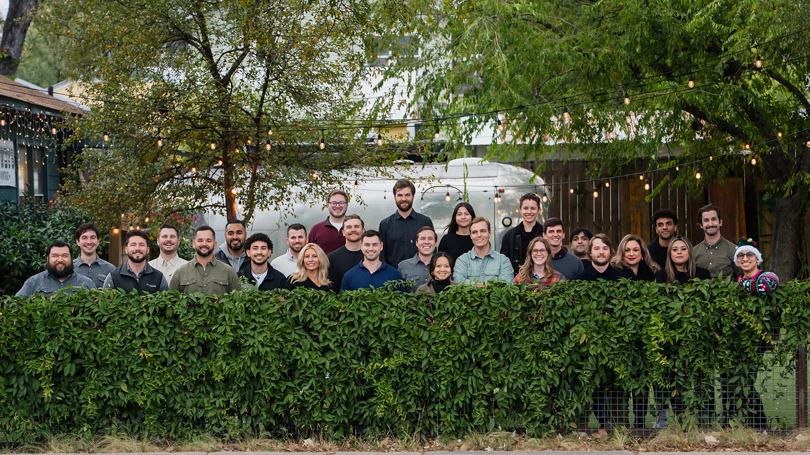 Buildforce team gathered outdoors behind a leafy fence