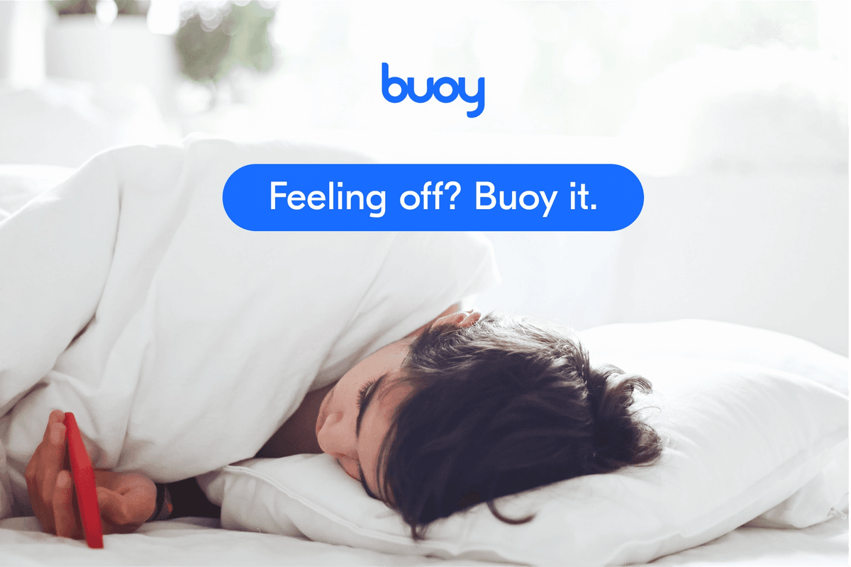 Buoy Health - a person in bed checking Buoy's AI Assistant on their phone, captioned 'Feeling off? Buoy it.'