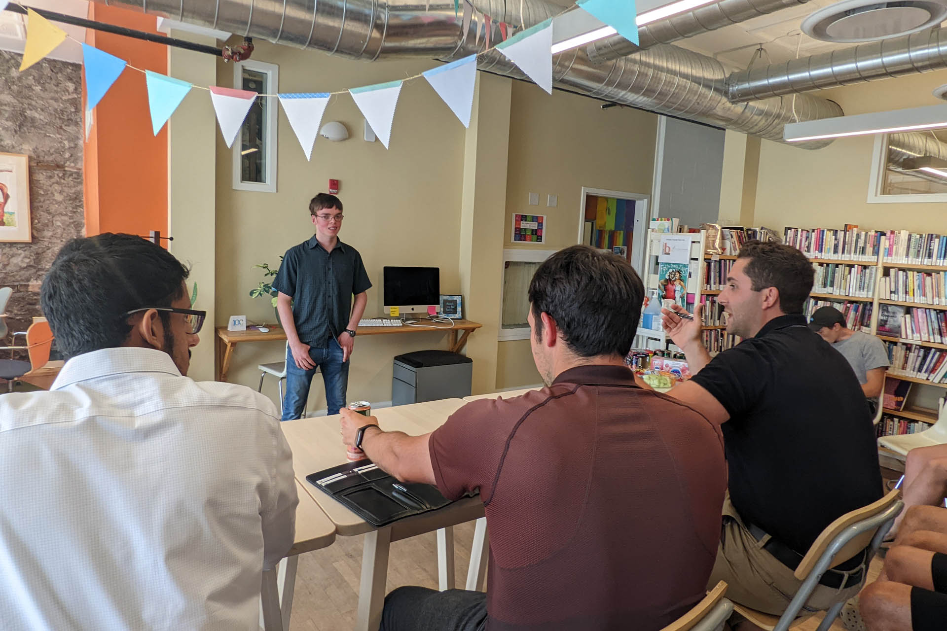A participant speaks to a small seated group in a Summer Company gallery photograph